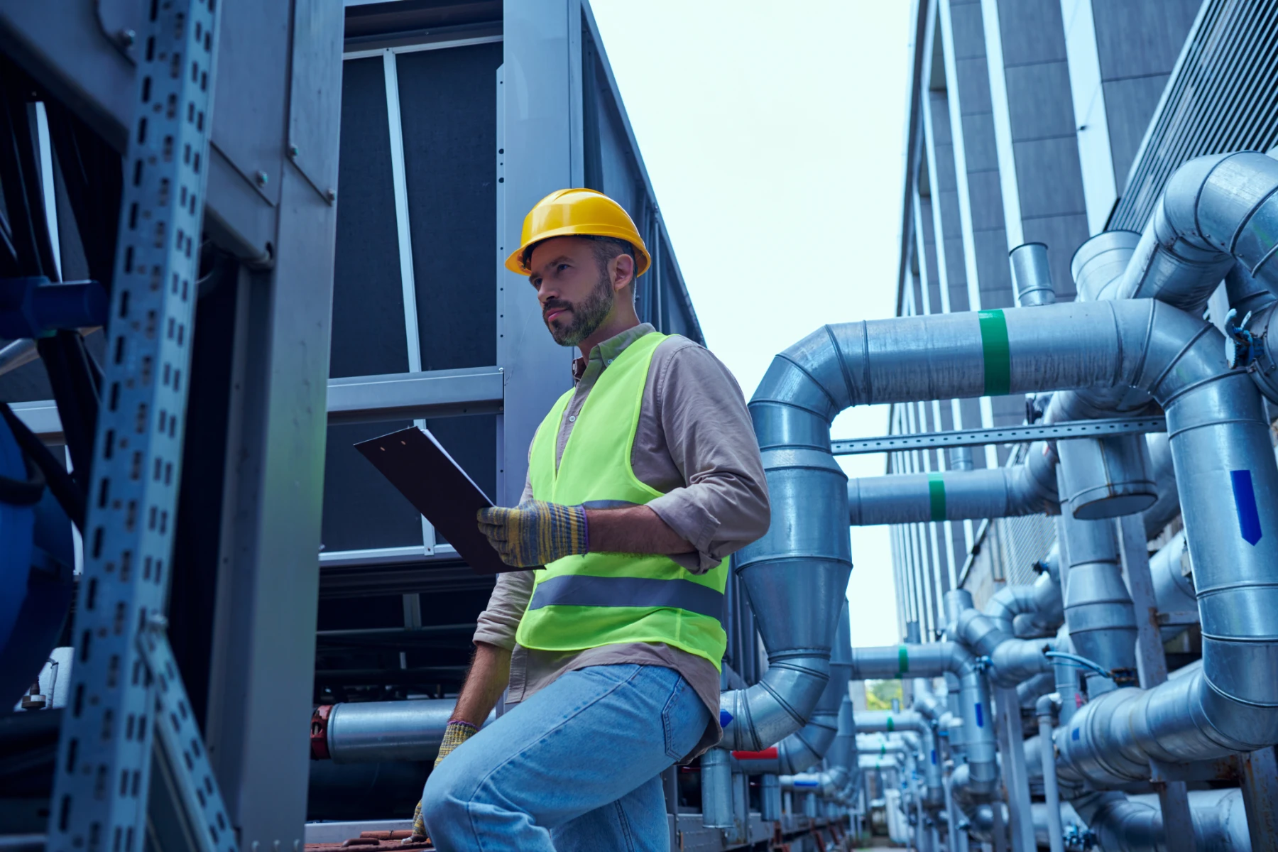 Construction Worker Inspecting Pipes in an Urban Setting